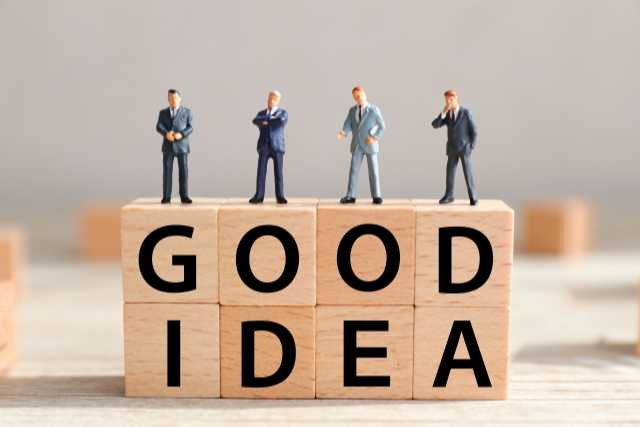 goodideaと書かれてある積み木の上に立つ４つの男性の置物