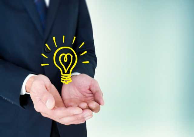 スーツの男性の手の上にある電球