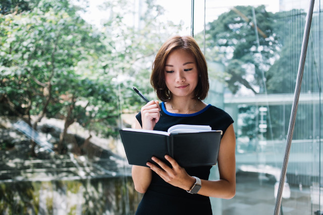 ノートをチェックする女性